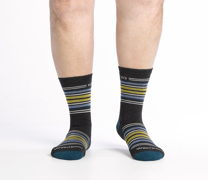 On model shot of Micro Crew socks with teal heel/toe and Cream logo, Charcoal body and blue and yellow stripes.