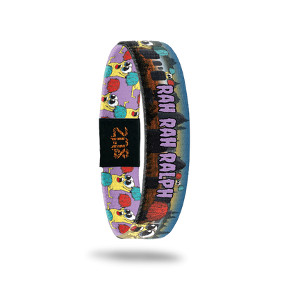 Product photo of the inside of 2021 - Day 1 - Rah Rah Ralph: graveyard background with yellow monsters holding a red and turquoise pom pom with purple "RAH RAH RALPH" text