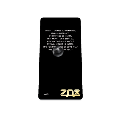Product photo of the back of the collector’s of 2021 - Day 10 - Leon Lovestruck. It is a black background with white text ‘When it comes to romance, Leon's obsessed. In matters of heart, this monster is blessed. He can't help but adore everyone that he meets. It's for pure sake of love that this heart beats.'