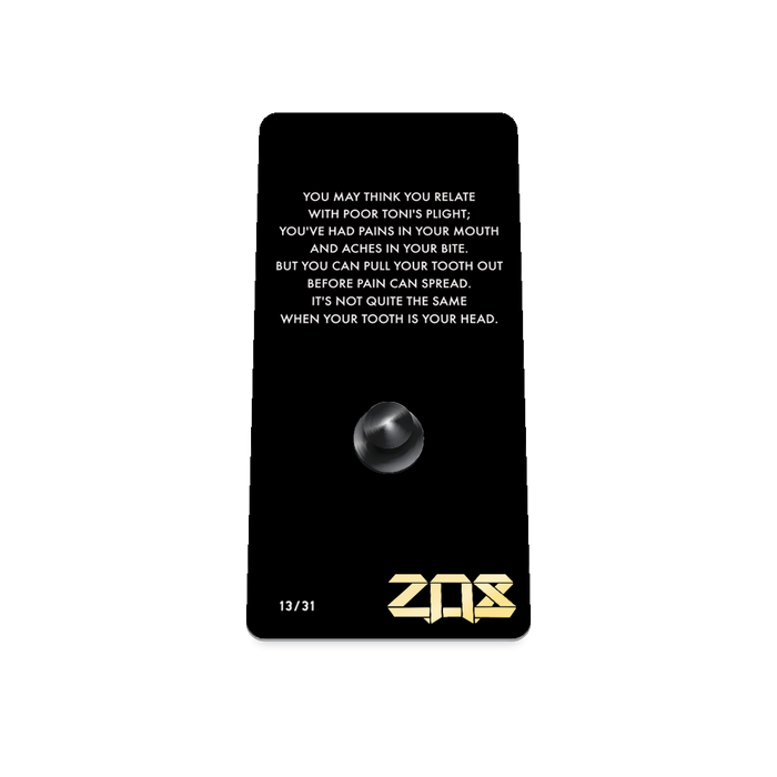 Product photo of the back of the collector’s of 2021 - Day 13 - Toni Toothache. It is a black background with white text ‘You may think you relate with poor Toni's plight; you've had pains in your mouth and aches in your bite. But you can pull your tooth out before pain can spread. It's not quite the same when your tooth is your head.'