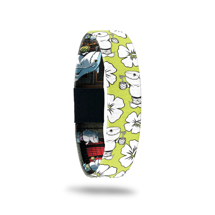 Bright yellow bracelet with Hawaiian flowers all over in white. The monster is a shark, smiling while drinking an adult beverage from a coconut in his swim trunks. Comes with a matching monster pin.
