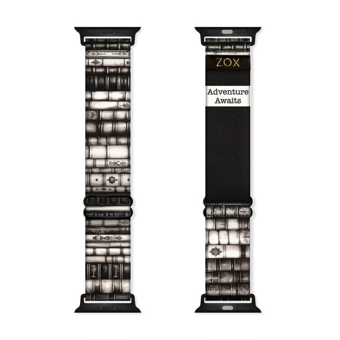 Watchband that is ornate books stacked on top of each other in various shades of black and white. The inside is the same and reads Adventure Awaits.