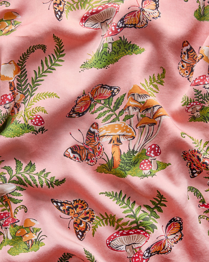 Close-up of the rosewood Butterfly Forager print featuring butterflies, mushrooms, and fern fronds.