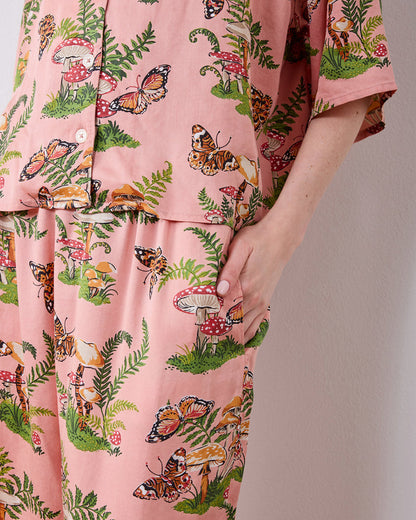 Close-up of the pink Butterfly Forager petite satin Wildest Dreams pajama set showing the button-front top and a side pocket on the wide-leg pants.