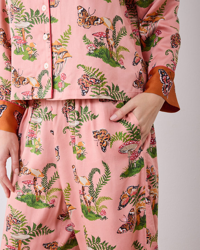 Close-up of the Butterfly Forager pajama set showing the button-front top, patterned wide-leg pants, and side pocket.