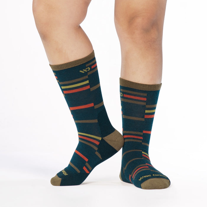model lifting foot on left wearing the 9010 crossroads cushioned crew in navy colorway