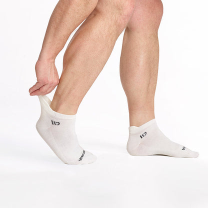 model stretching the back of the left foot sock wearing the 9013 lightweight ankle sock in white