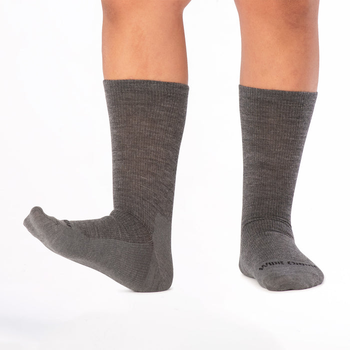 Model lifting the left foot toes up wearing the 9012 solid lightweight crew in gray