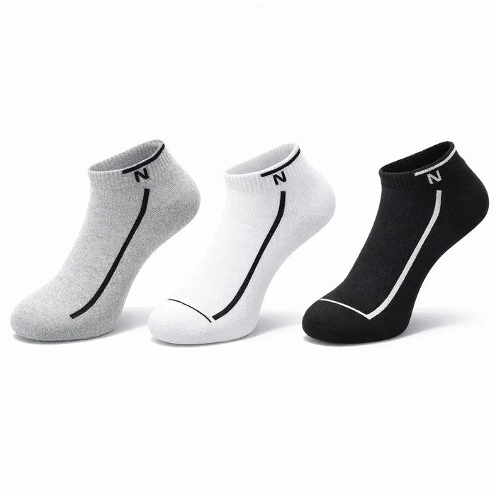 Three pairs of socks in gray, white, and black on a white background