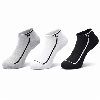 Three pairs of socks in gray, white, and black on a white background