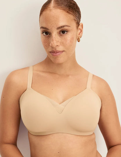 Adecia is a 34D wearing KNIX M+ | Front view of model wearing the Shape & Smooth Bra, highlighting the neckline, strap design, and smooth silhouette | Warm Sand