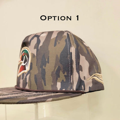 Camouflage baseball cap with a logo on a clear stand against a beige background