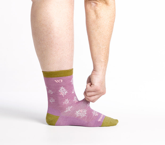on model image of model stretching the top of the foot on the 9503 Foliage micro crew sock in violet