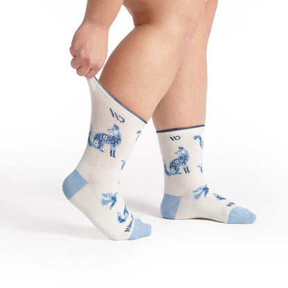 models feet pointed right and stretching the back cuff on the women's woodland wonder lightweight micro crew in white