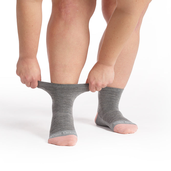 Models feet facing forward stretching the cuff on the 9515 Solid lightweight quarter sock in light gray featuring gray body and pink toe/heel