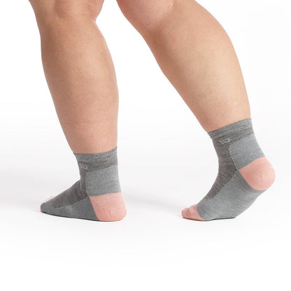 Model walking away in the 9515 solid lightweight quarter sock in light gray focusing on the pink heel and white logo