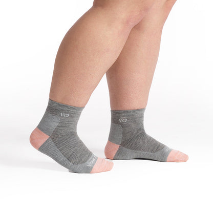 Models feet walking to the right wearing the 9515 solid lightweight quarter sock in light gray showing the pink heel/toe and white logo