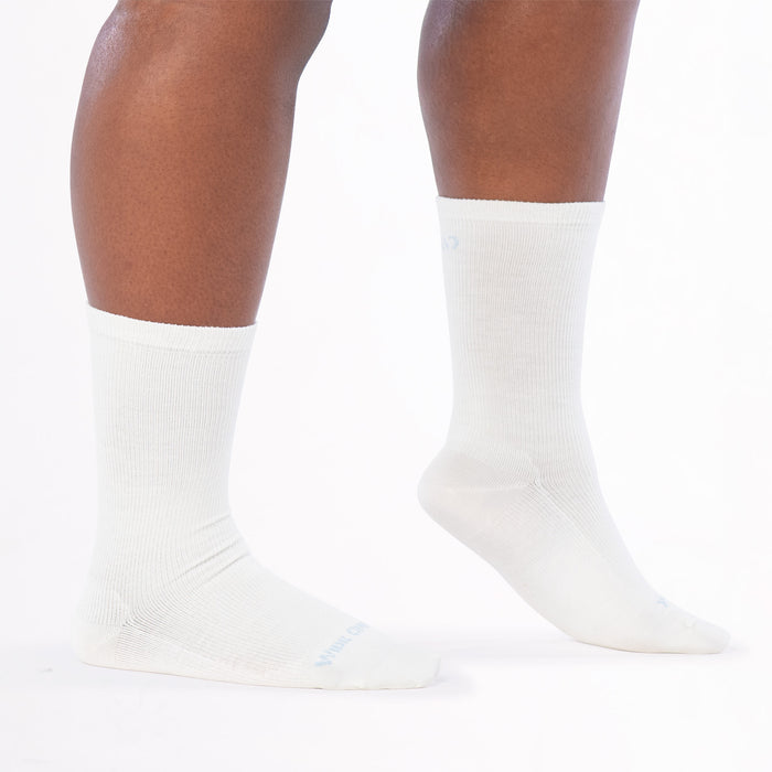 models feet to the right with front foot lifted on toes wearing the 9513 solid basic lightweight crew in white